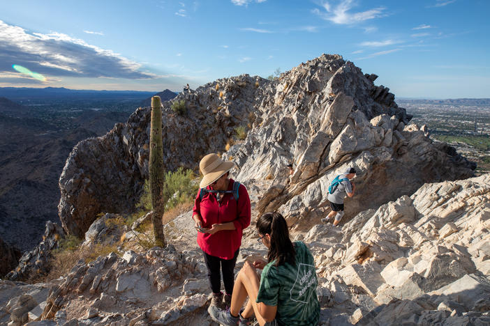 Early morning hikers rest before walking down Piestewa Peak, a city park in Phoenix, Ariz. El Niño drives even hotter, drier weather in the Southwest United States, on top of growing heat risk from human-caused climate change.
