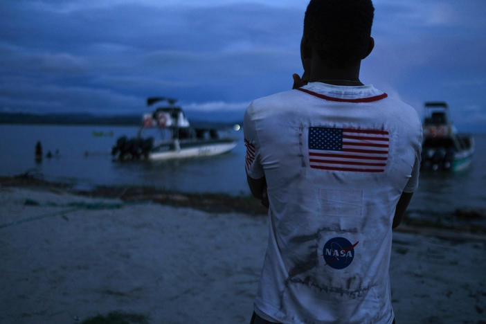 A Venezuelan migrant watches the boat he hopes to take across the Gulf of Urabá once he gets enough money together for the trip.