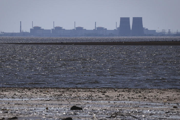 The Zaporizhzhia nuclear power plant, Europe's largest, is seen in the background of the shallow Kakhovka Reservoir. Water levels in the reservoir have been falling rapidly after a critical dam collapsed.