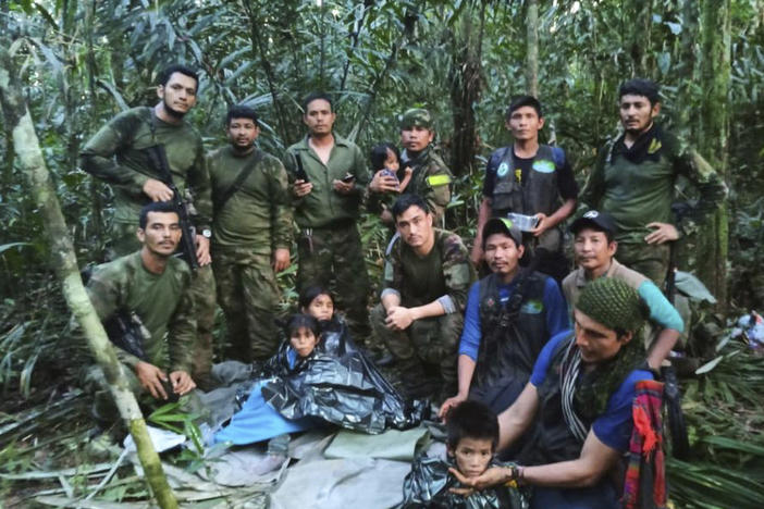 In this photo released by Colombia's Armed Forces Press Office, soldiers and others pose for a photo on Friday with the four children who were missing after a deadly plane crash in the Solano jungle, Caqueta state, Colombia.