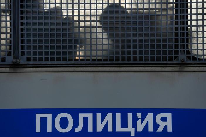 Silhouettes of detained people are seen in a police truck near the Moscow City Court during the trial of a Russian opposition leader in Moscow on February 2, 2021.