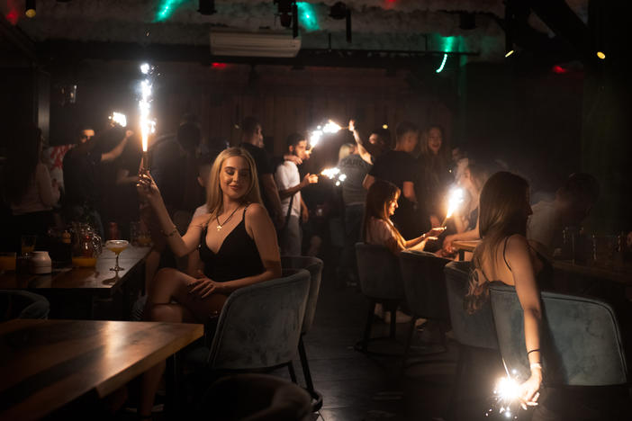 Patrons at a club in Kharkiv hold sparklers in the darkened room in eastern Ukraine. Despite the ongoing war, people are still finding a way release tension in nightclubs in the the battered city.