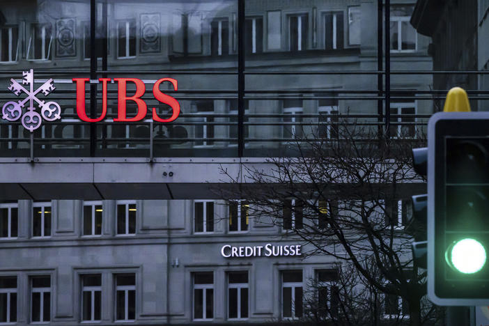 A traffic light signals green in front of the logos of the Swiss banks Credit Suisse and UBS in Zurich, Switzerland, March 19, 2023.