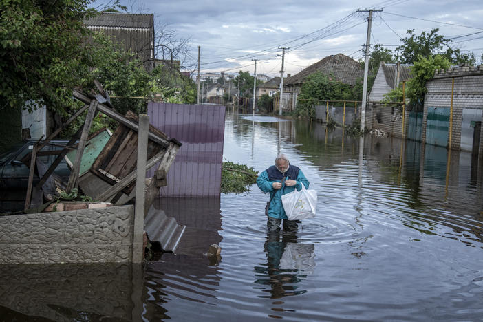 A resident walks on Sunday in a flooded street after the Kakhovka Dam burst and unleashed floodwaters, in Kherson, Ukraine.