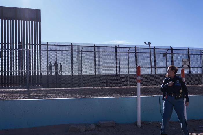 A U.S. law enforcement officer stands guard by a fence along the U.S.-Mexico border at El Paso, Texas.