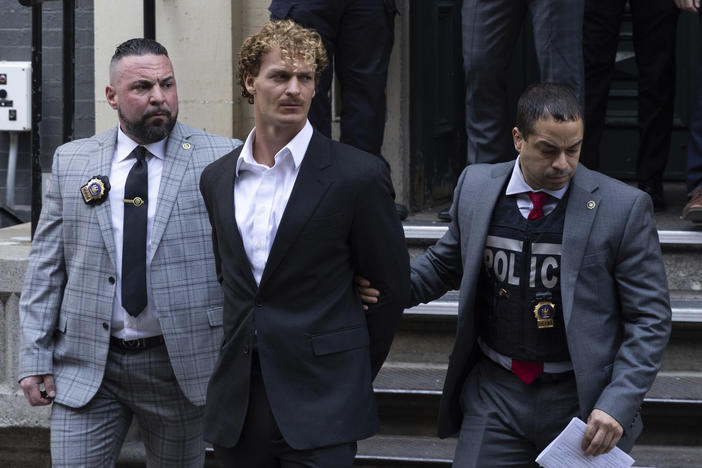 Daniel Penny, center, is walked by New York Police Department detectives out of the 5th Precinct on Wednesday.