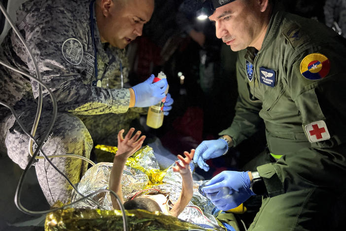 Soldiers of the Colombian Air Force give medical attention inside a plane to the children who survived a Cessna 206 plane crash in the thick jungle, while they are transferred to Bogotá by air in San José del Guaviare, Colombia, June 9.