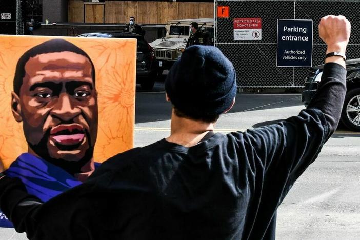 An demonstrator holds a portrait of George Floyd in March 2021 outside the Hennepin County Government in Minneapolis, where the trial of former Minneapolis Police Department officer Derek Chauvin in Floyd's killing was under way.