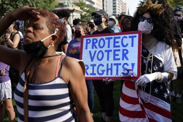 A demonstrator holds a sign saying "PROTECT VOTER RIGHTS!" at a 2021 rally in Washington, D.C., calling for Congress to pass new voting rights legislation.