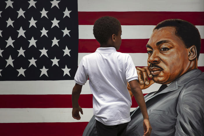 A young boy walks past a painting depicting Dr. Martin Luther King Jr. during a Juneteenth celebration in Los Angeles in 2020. Juneteenth marks the day in 1865 when federal troops arrived in Galveston, Texas, to take control of the state and ensure all enslaved people be freed, more than two years after the Emancipation Proclamation.