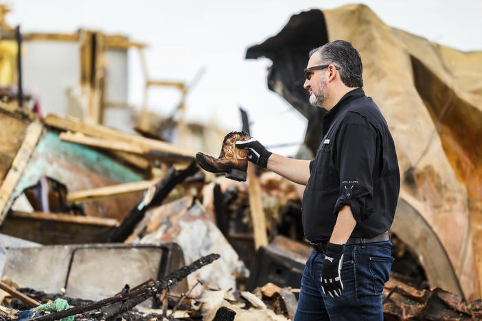 Sen. Ted Cruz, R-Texas, holds up a small cowboy boot he recovered from debris in a trailer park that was damaged by a tornado earlier in Perryton, Texas, Saturday, June, 17, 2023.