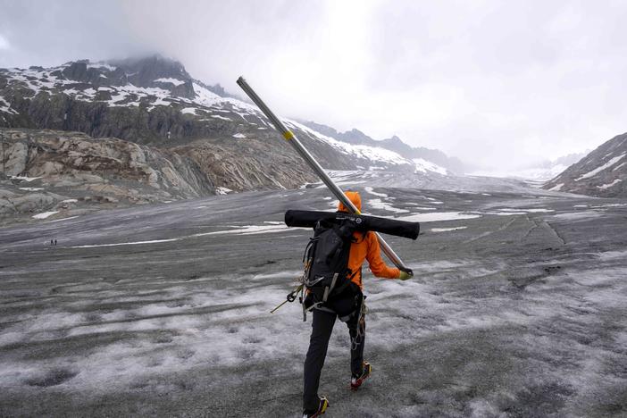 Matthias Huss, a glaciologist and head of the Swiss measurement network 'Glamos', for ETH (the Swiss Federal Institute of Technology) walks up to the Rhone Glacier near Goms, Switzerland, Friday, June 16, 2023.