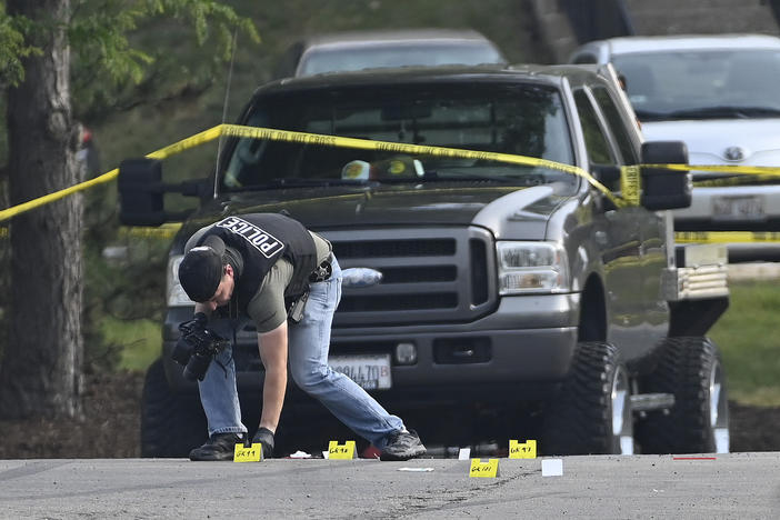 A police officer works the scene of an overnight mass shooting at a strip mall in Willowbrook, Ill., Sunday, June 18, 2023.