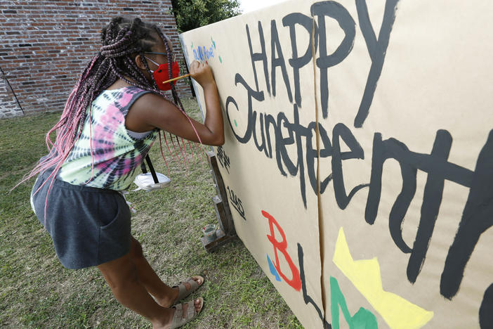 Amya Watson, 11, prints "Black Power" on a poster celebrating Juneteenth during the "Black Joy as Resistance! Juneteenth Celebration" in the historic Farish Street business district in downtown Jackson, Miss.