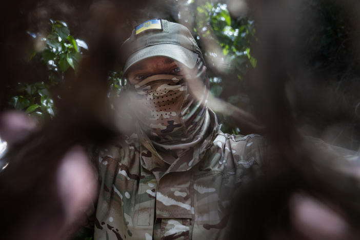 Michel looks through some camouflage netting near his home in Kherson.