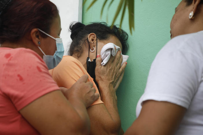 Relatives of inmates wait in distress outside the entrance to the women's prison in Tamara, on the outskirts of Tegucigalpa, Honduras, Tuesday, June 20, 2023.