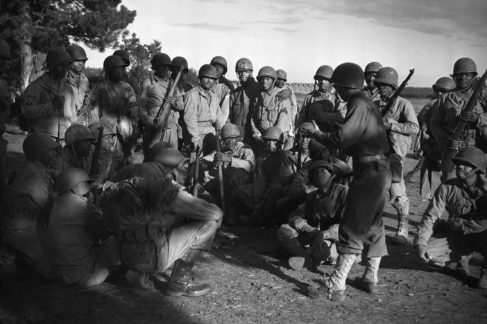 Lt. Frank J. Crawford of Detroit, Michigan, as the Regimental plans and training officer, is giving his men instructions in combat maneuvers.