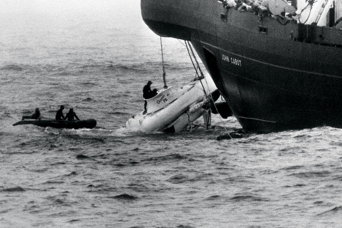 Divers begin to open the hatch of Pisces III as she breaks water under the John Cabot after being hauled from the Atlantic seabed off the coast of Cork, Ireland.