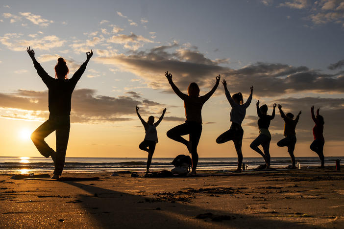 Members of the Happy Seal Yoga class practice on Cayton Bay in Scarborough as the sun rises to celebrate the Summer Solstice, Wednesday June 21, 2023.