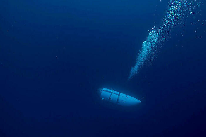 An undated photo shows a tourist submersible belonging to OceanGate descending into the ocean. Search and rescue operations for one of the company's submersibles, Titan, are continuing Wednesday.