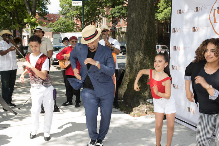 Eddie Torres Jr. and Princess Serrano dance with two young salseros at the first pop-up of the International Salsa Museum