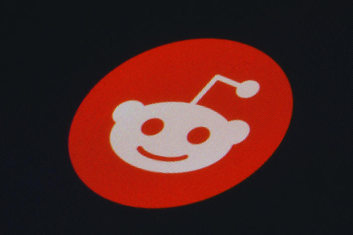 Reddit's updates will include access to moderation tools, messaging, and control settings for user approval and bans. The Reddit app icon is pictured on a smartphone.