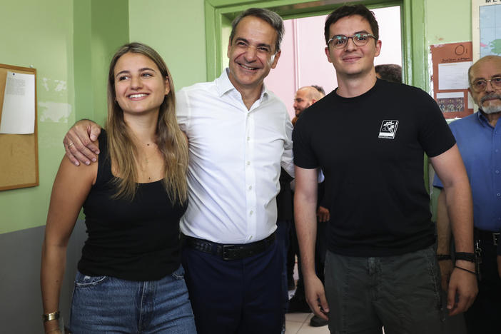 Kyriakos Mitsotakis, center, leader of center-right New Democracy party poses for the media with his daughter Dafni Mitsotakis, left, and son Konstantinos Mitsotakis at a polling station in Athens, Greece, on Sunday.