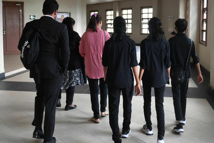 Loh Siew Hong, in a pink shirt, arrives with her three children at Kuala Lumpur High Court for a hearing on May 11.