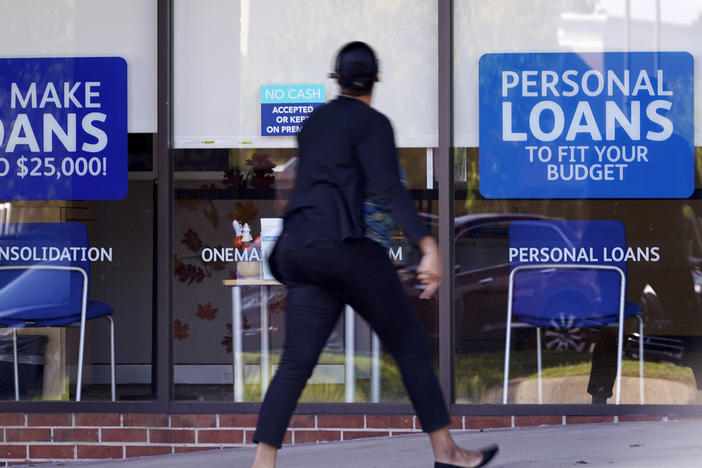 A woman walks past a personal finance loan office in October 2020 in Franklin, Tenn.