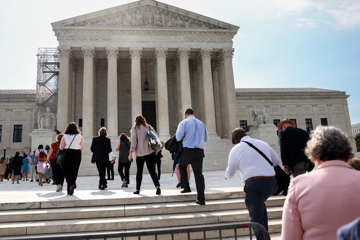 People walk into the U.S. Supreme Court in Washington, D.C., on Tuesday, the day that the court's majority rejected the once-fringe idea that state legislatures' power over congressional elections cannot be checked or balanced by state constitutions or state courts.