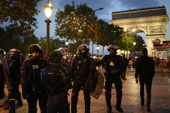 Police officers patrol in front of the Arc de Triomphe on the Champs Elysees in Paris on Saturday.