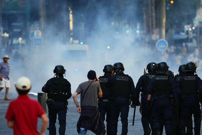 Police officers walk as they try to disperse protesters with tear gas during a demonstration against police in Marseille, southern France on July 1.