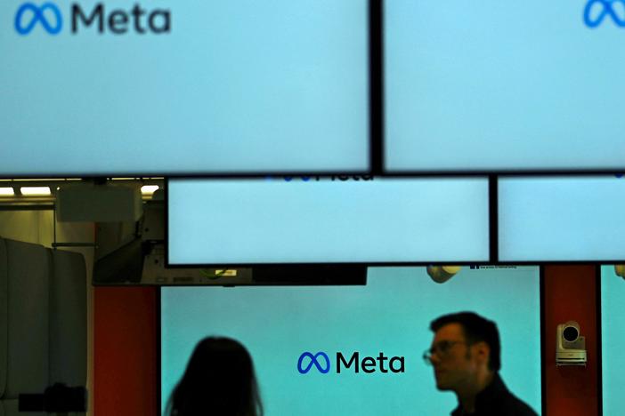 Visitors stand near screens displaying the Meta logo in Berlin on June 6. Under a U.S. judge's new ruling, much of the federal government is now barred from working with social media companies to address removing content that might contain "protected free speech."