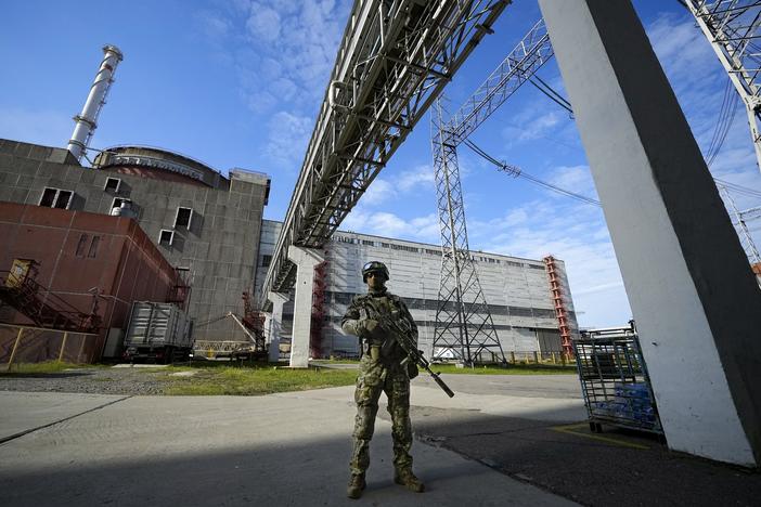 A Russian serviceman guards the Zaporizhzhia Nuclear Power Plant in in southeastern Ukraine in May 2022. Ukrainian President Volodymyr Zelenskyy says Russia has placed devices that look like explosives on top of reactors at the plant. He says Russia may carry out sabotage and blame Ukraine. Russia, in turn, says Ukraine is planning to attack the plant.