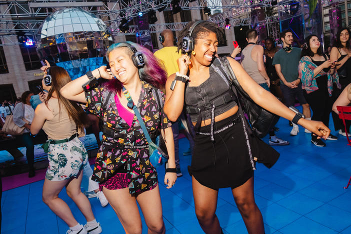 Concert goers dancing at the Silent Disco dance party at Lincoln Center, New York City on Saturday, July 1, 2023. Haptic suits designed for the deaf community were provided by Music: Not Impossible.