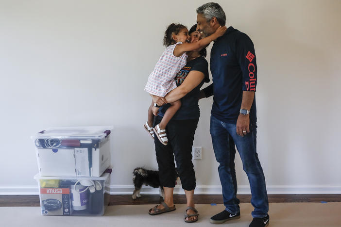 During the pandemic, the number of young children in urban U.S. counties saw significant declines. Joyce Lilly, center, holds her granddaughter Paige alongside her husband, Anil, at their new home in July 2020 in Washingtonville, N.Y.