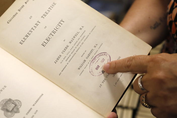 New Bedford Public Library Director Olivia Melo on Friday points to a stamp dating to 1882 when the New Bedford library system acquired the book.