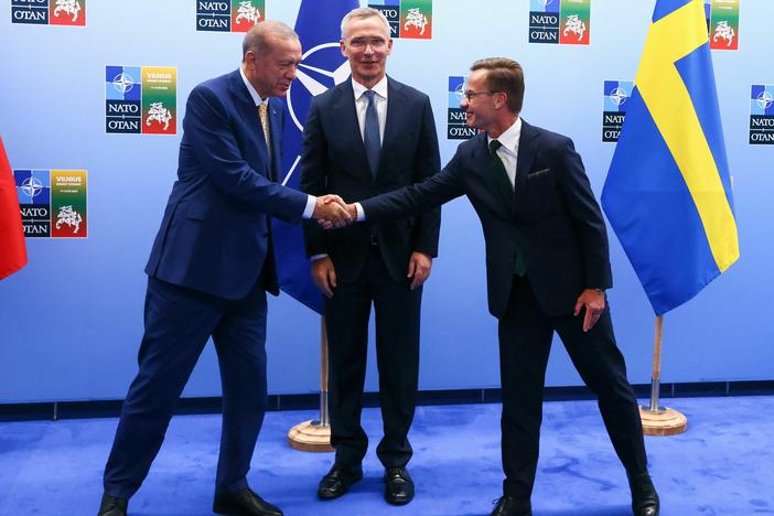 Turkish President Tayyip Erdogan (L) and Swedish Prime Minister Ulf Kristersson shake hands next to NATO Secretary-General Jens Stoltenberg prior to their meeting in Vilnius on Monday.