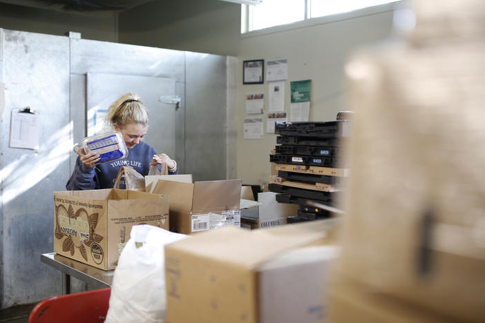 Volunteer Ella Cagle of Wake Forest loads bags with frozen meat. The food bank serves individuals and families in need with a week's worth of groceries.