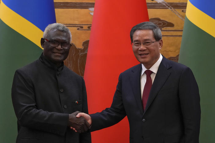 Visiting Solomon Islands Prime Minister Manasseh Sogavare, left, shakes hands with his Chinese counterpart Li Qiang after they witnessed signing on agreement for both countries at the Great Hall of the People in Beijing, Monday, July 10, 2023.