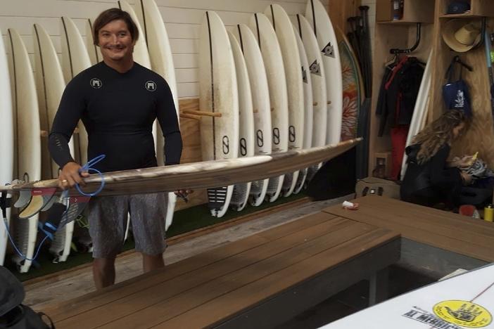 This May 19, 2019, photo provided by Dr. John Jones shows Mikala Jones at Surf Ranch in Lemoore, Calif., holding a surfboard his brother Daniel Jones made using material from the agave plant.