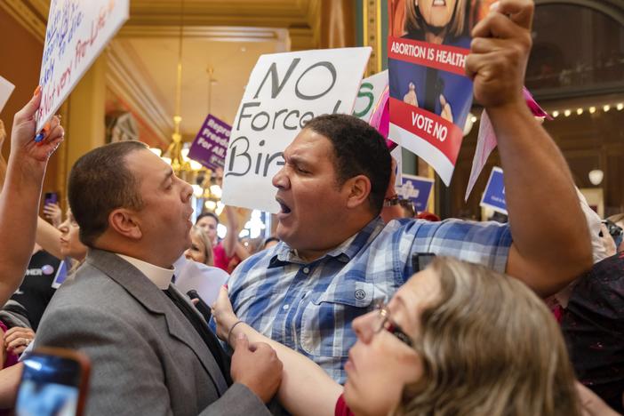 Pastor Michael Shover of Christ the Redeemer Church in Pella, Iowa, left, argues with Ryan Maher, of Des Moines, as protesters clashed in the Iowa State Capitol rotunda, while the Iowa Legislature convened for a special session on July 11, 2023.