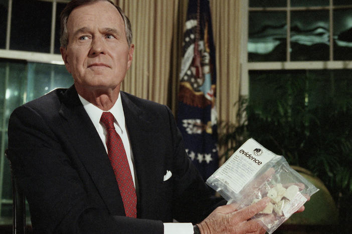 President George H. W. Bush holds a bag of crack cocaine as he poses for photographers in the Oval Office of the White House, Sept. 5, 1989.