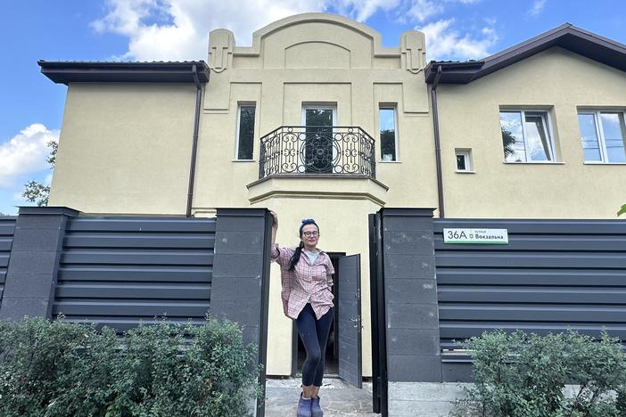 Olha Kornych, 58, stands in front of her newly rebuilt home on Vokzalna Street in Bucha, a suburb of Kyiv. Her home was among the many that were badly damaged or destroyed in Russia's full-scale invasion in February 2022.