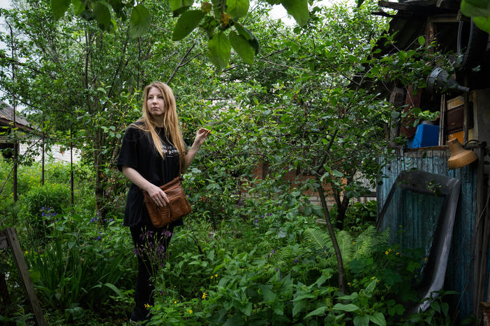 Victoria Amelina stands next to a cherry tree in the backyard of Volodymyr Vakulenko, a Ukrainian children's book author, where he buried his diary of living under Russian occupation in Kapytolivka before he was killed.