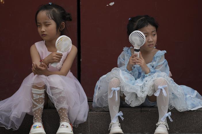 Children cool themselves with electric fans in Beijing on June 25, 2023. The National Oceanic and Atmospheric Administration says this was the hottest June on record globally.