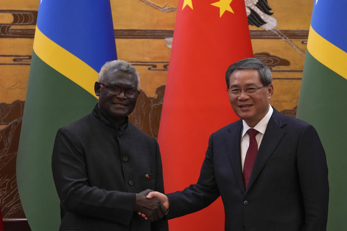 Visiting Solomon Islands Prime Minister Manasseh Sogavare, left, shakes hands with his Chinese counterpart Li Qiang after they witnessed signing on agreement for both countries at the Great Hall of the People in Beijing, Monday, July 10, 2023.