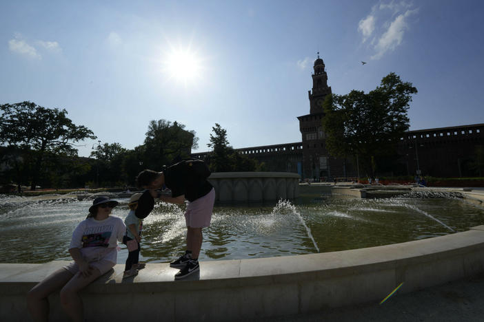 Tourists cool off in a public fountain at the Sforzesco Castle, in Milan, Italy, on Saturday. Temperatures reached up to 42 degrees Celsius in some parts of the country, amid a heat wave that continues to grip southern Europe.