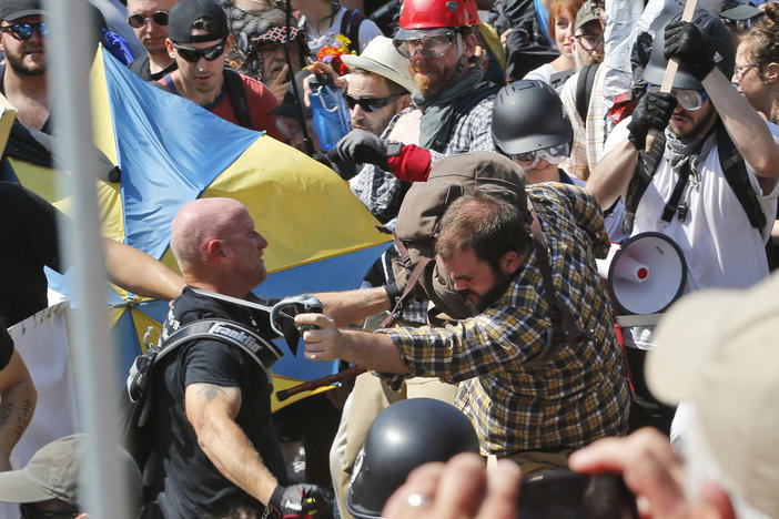 In this Aug. 12, 2017 file photo, white nationalist demonstrators clash with counter demonstrators at the entrance to Lee Park in Charlottesville, Va.