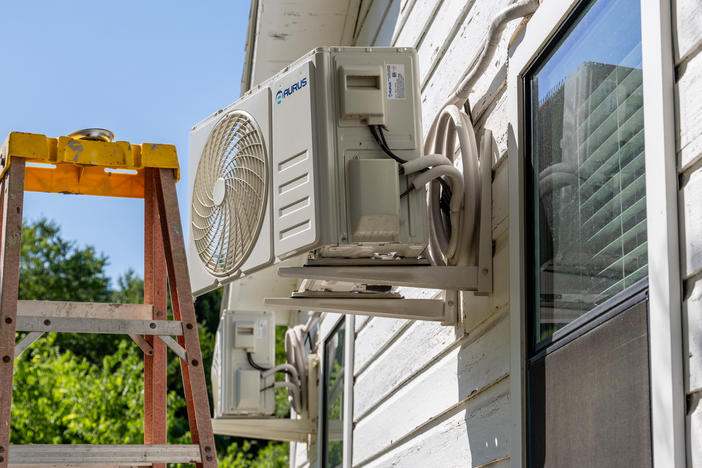 An air conditioner undergoes repair earlier this month in Austin, Texas. Record-breaking temperatures continue across large swaths of the U.S.